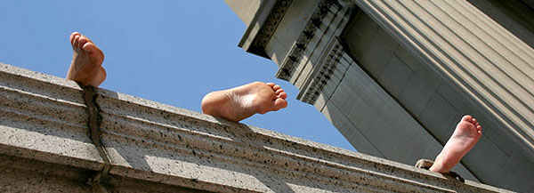 Students sun themselves on a ledge near the steps of Low Library.