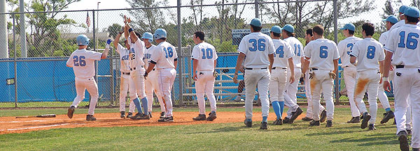 The Columbia Lions baseball team comes out to congratulate a team member scoring the winning run.