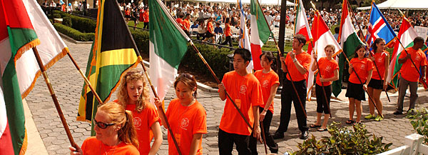 Students carry flags representing the nationalities of the student body.