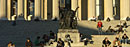 Students bask in the afternoon sun around Alma Mater on a fall day.